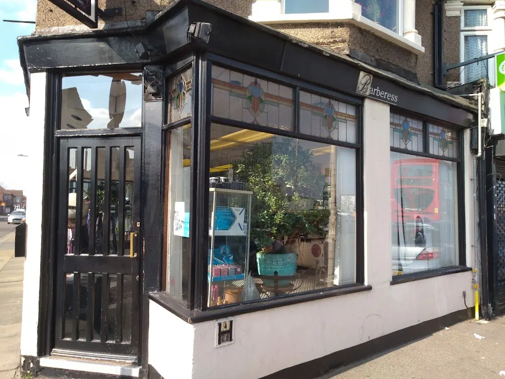 The salon front with a black door and wide windows